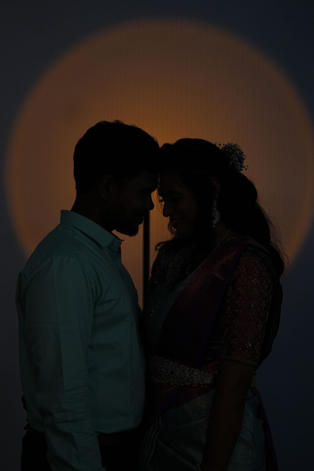 Yuvasriee and Yokesh in silhouette against a warm light
