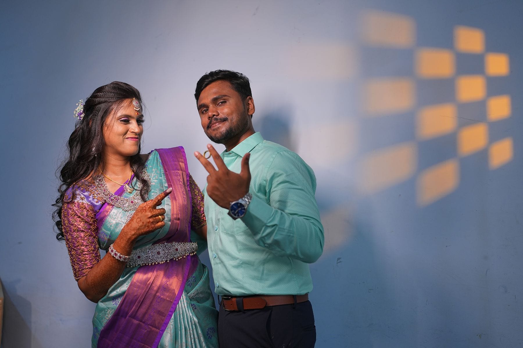 The two of them laughing against the blue wall